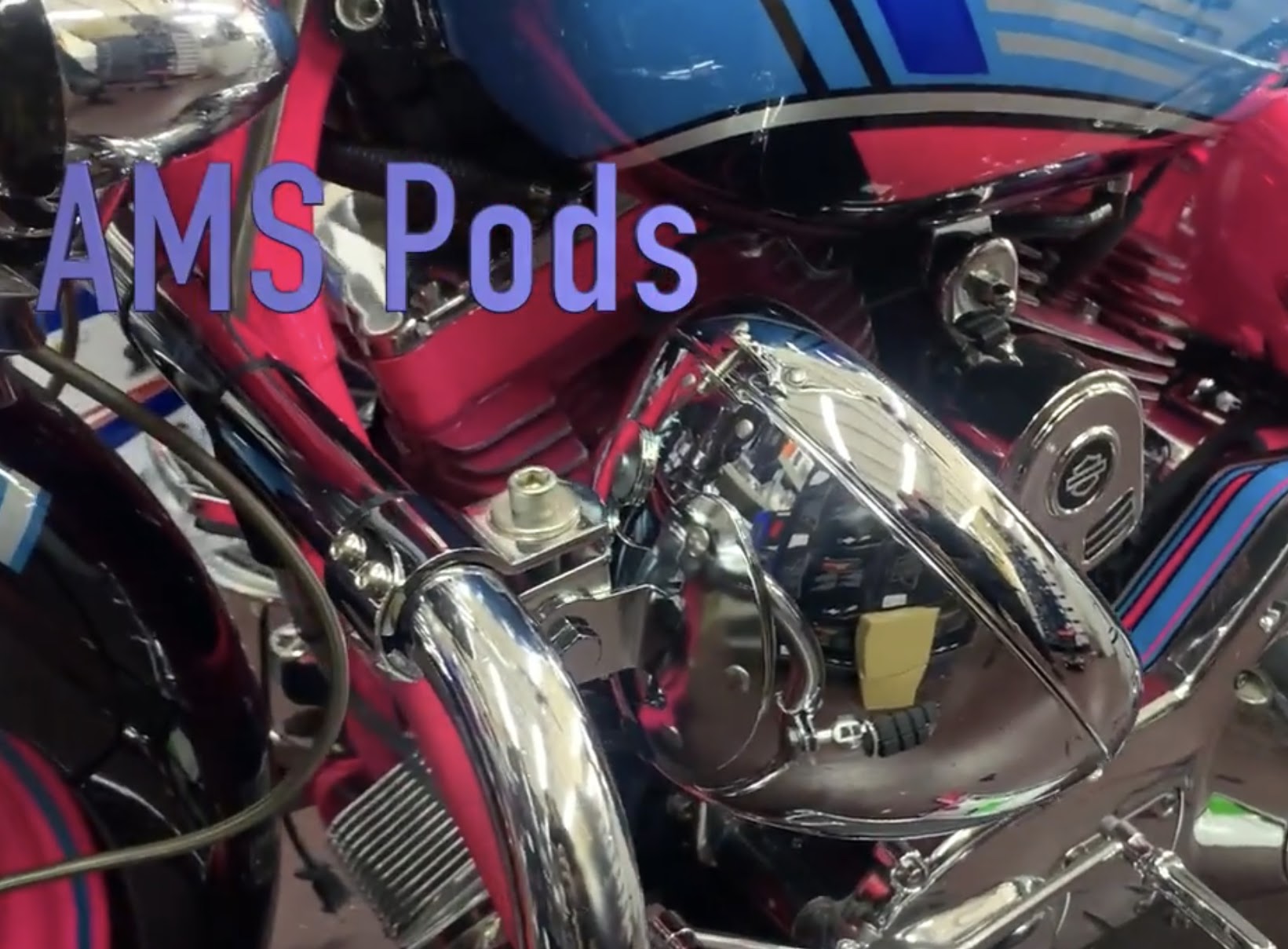 Pink Harley bagger with a chrome crash-bar speaker pod